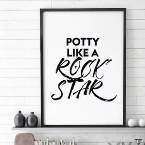 Könnte beinhalten: Schwarz-weißes druckbares Wandbild mit dem Text "Potty like a rock star" in einer fetten, handgeschriebenen Schrift.