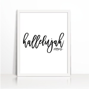 Könnte beinhalten: Ein weiß gerahmter Druck mit dem Wort "hallelujah" in schwarzer, handschriftlicher Schrift. Darunter steht ein kleineres hebräisches Wort. Der Hintergrund ist schlicht weiß.