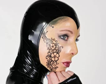 May include: A person wearing a black latex bodysuit with a floral design on their face. The design is black and white and covers the right side of their face.