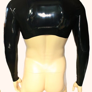 May include: A black, long-sleeved, cropped top made of shiny latex. The top has a high neck and a close fit.