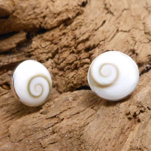 May include: A pair of silver earrings with white shell cabochons featuring a brown spiral pattern.