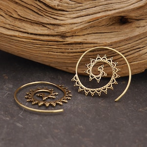 Könnte beinhalten: Ein Paar goldfarbene Spiralohrringe mit einem komplizierten durchbrochenen Design und kleinen dekorativen Schlaufen am Außenrand. Die Ohrringe haben eine kreisförmige, gewundene Form, die spitz zuläuft und ein detailliertes Metallmuster aufweist.
