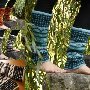 Könnte beinhalten: Vier Paar gestrickte Beinstulpen in verschiedenen Farben und Mustern. Die Beinstulpen sind an den Beinen einer Person zu sehen, wobei die Unterseite der Beinstulpen auf einem Stein ruht. Die Beinstulpen sind aus einem weichen, warmen Garn gefertigt und perfekt, um Ihre Beine im Winter warm zu halten.