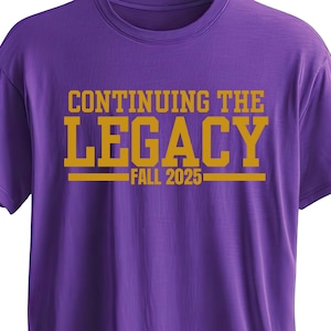 Puede incluir: Una camiseta morada con el texto dorado "CONTINUING THE LEGACY FALL 2025". La camiseta tiene mangas cortas y cuello redondo. El diseño incluye el texto "A. Nicole Designs" en una fuente cursiva con estrellas.