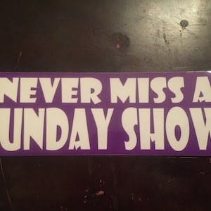 May include: Purple sticker with white text that reads "Never Miss A Sunday Show".