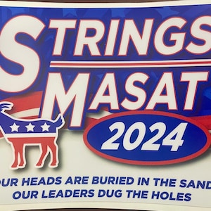 May include: A red, white and blue political campaign sticker featuring a goat and the text "STRINGS MASAT 2024". The sticker also includes the text "OUR HEADS ARE BURIED IN THE SAND, OUR LEADERS DUG THE HOLES".