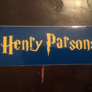 May include: A blue and yellow sticker with the text "Henry Parsons" in a stylized font. A lightning bolt is between the words.