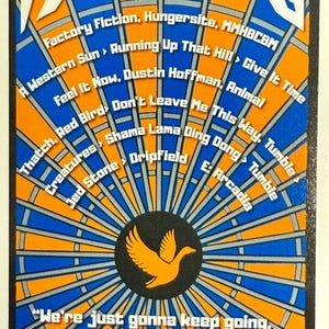 May include: A vibrant poster with a blue and orange radial design. The poster features a stylized logo at the top and a central emblem of a bird. Text includes song titles and the phrase "We're just gonna keep going." The date 6-28-25 and "NEW YORK CITY" are also visible.
