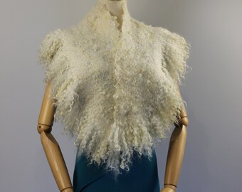May include: A white fluffy shawl with a textured, curly design. The shawl is draped over a mannequin wearing a teal skirt.