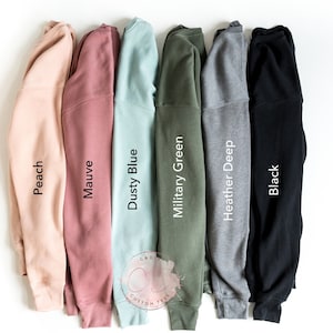 May include: Six different colored sweatshirts, from left to right: peach, mauve, dusty blue, military green, heather deep, and black.