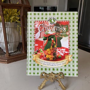 May include: A green and white plaid cookbook titled "Gooseberry Patch Christmas Book 9" with a picture of a jar filled with colorful candies. The text on the cover reads "Our tastiest Christmas recipes, gifts to make & give, and fresh ideas that make the season sparkle."