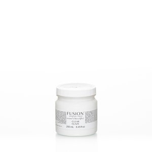 May include: A white jar of Fusion Mineral Paint Clear Glaze, labeled with the brand name and product description. The jar contains 8.45 ounces (250 ml) of glaze.