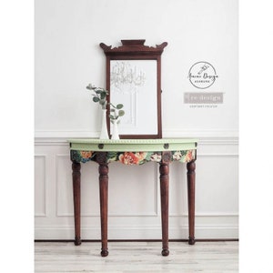 May include: A vintage wooden console table with a green painted top and floral patterned design. The table has three legs and a curved top. A mirror with a decorative frame is hanging above the table.