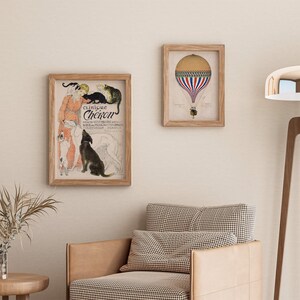 May include: A framed print of a vintage advertisement for "Clinique Cheiron", featuring a woman with a group of dogs and cats. The print is in a light wood frame and is hanging on a light beige wall. There is a second framed print of a hot air balloon in the background.