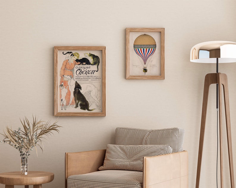 May include: A framed print of a vintage advertisement for "Clinique Cheiron", featuring a woman with a group of dogs and cats. The print is in a light wood frame and is hanging on a light beige wall. There is a second framed print of a hot air balloon in the background.