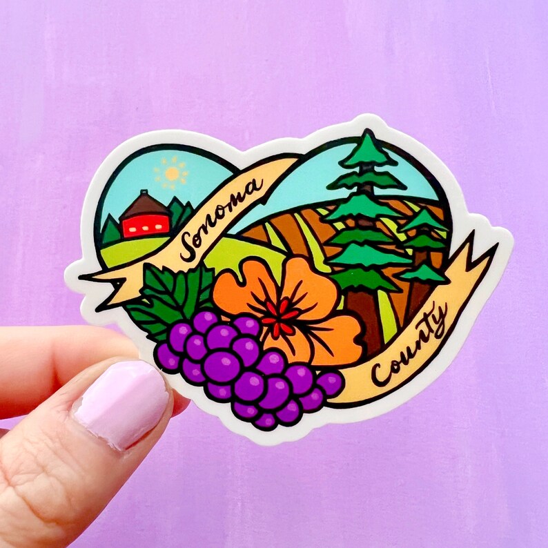 May include: A heart-shaped sticker with a colorful illustration of a vineyard landscape, a red barn, a sun, a flower, grapes, and two pine trees. The sticker has the text "Sonoma County" in a yellow banner.