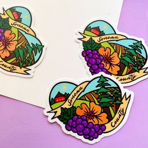 May include: Three heart-shaped stickers with a colorful illustration of a farmhouse, grapes, a flower, and trees. The stickers say "Sonoma County" in a handwritten font.