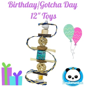 Puede incluir: Un juguete de cumpleaños o de día de adopción para mascotas pequeñas de 30 cm. El juguete está hecho de materiales naturales y presenta una variedad de texturas y formas. Incluye una clavija de madera, una bola tejida, un pequeño bloque de madera con el texto "Happy 9th Gotcha Day Phil!" y una cinta azul y blanca.