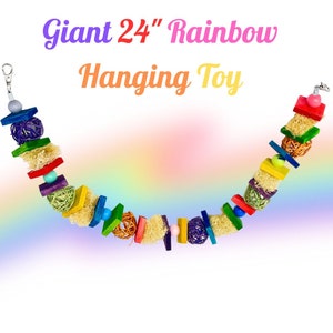 Puede incluir: Un juguete colgante de arcoíris de 61 cm de largo para animales pequeños. El juguete está hecho de madera, cuerda de sisal y bolas tejidas. Tiene un clip de metal para colgar.