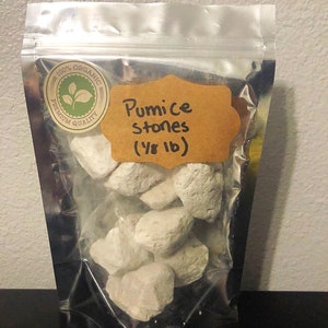 May include: A clear plastic bag filled with white pumice stones. The bag has a label that says "100% Organic Premium Quality" and "Pumice Stones (1/8 lb)".