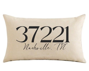 Puede incluir: Una almohada beige con texto negro que dice "37221 Nashville, TN".