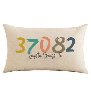 May include: Beige throw pillow with the numbers 37082 in colorful, brushstroke-style font. The text "Kingston Springs, Tn" is written below the numbers.