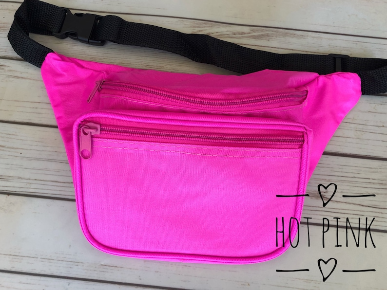 May include: Hot pink fanny pack with a black adjustable strap and two zippered compartments. The text "HOT PINK" is written on the front of the pack.