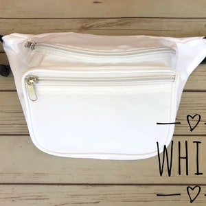 May include: White fanny pack with two zippered compartments. The fanny pack has a black strap and is made of a smooth, white fabric.