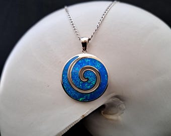 Könnte beinhalten: Eine silberne Halskette mit einem blauen Opal-Anhänger mit Spiraldesign.