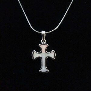 May include: A silver chain necklace with a white and pink opal cross pendant.