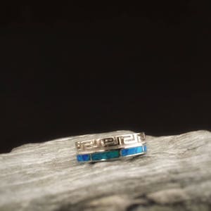Op de afbeelding: Een zilveren ring met een blauwe opaal-inleg en een Grieks sleutelmotief.