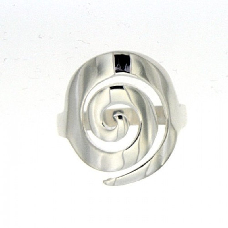 May include: A silver ring with a spiral design. The ring is made of polished metal and has a smooth finish.