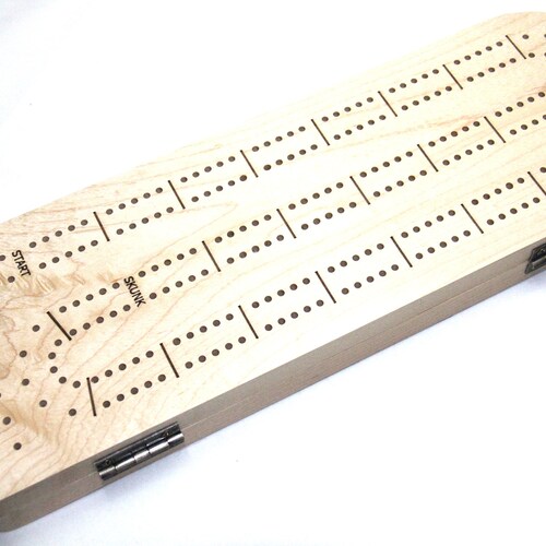 Cribbage Boards in various designs and Materials. Includes Pegs and