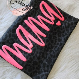 May include: Black and grey leopard print t-shirt with the word "mama" in pink lettering.