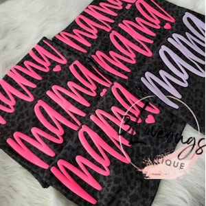 May include: Three black and white leopard print fabric pouches with the word "mama" written in pink and purple lettering.