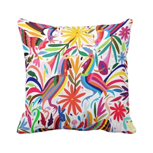 May include: Square throw pillow with a vibrant, colorful design. The pillow features a white background with a repeating pattern of stylized birds, flowers, and foliage in shades of red, blue, yellow, and green. The design has a folk art style.