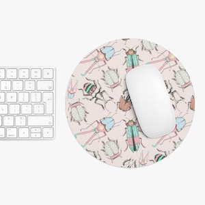 May include: A round pink mouse pad with a repeating pattern of colorful beetles. The beetles are drawn in a whimsical style with details like spots and stripes.