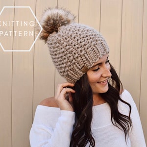 May include: A beige knitted beanie with a fluffy brown pom pom. The beanie is made with a chunky yarn and has a ribbed texture.  "Knitting Pattern" is written in white text on a white hexagonal background.