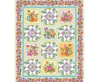 May include: A quilt with a floral pattern. The quilt is made up of squares with different floral designs. The quilt is surrounded by a border of smaller floral designs.