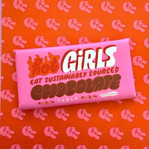 Op de afbeelding: Roze chocoladeverpakking met de tekst "Hot Girls Eat Sustainably Sourced Chocolate" in witte en bruine letters met een vlamgrafiek. De verpakking heeft de tekst "Table Chocolate" en "@lizharrydesign" in kleinere tekst.