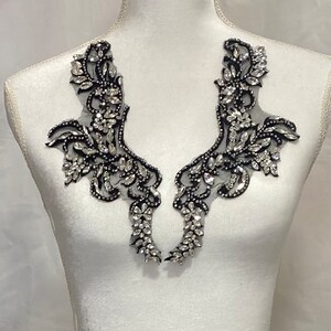 May include: Two black lace appliques with silver rhinestones, perfect for adding a touch of sparkle to a garment.