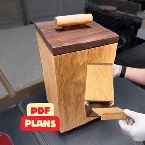 Op de afbeelding: Een hoge houten opbergcontainer met een lichtgekleurde houten behuizing en een donkerhouten deksel met een cilindervormige handgreep. Een kleiner, bijpassend houten onderdeel wordt aan de zijkant vastgehouden. De tekst PDF PLANS staat in een rood-gele afbeelding.