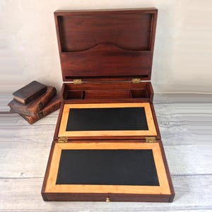 Escritorio antiguo de caoba con incrustaciones, cajón, soporte para cartas y reposaplumas.