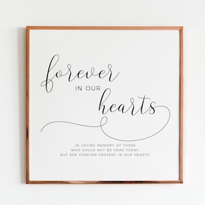 May include: A framed print with the text "forever in our hearts" in a cursive font. The text is in black on a white background. Below the text is a smaller quote that reads "In loving memory of those who could not be here today, but are forever present in our hearts."