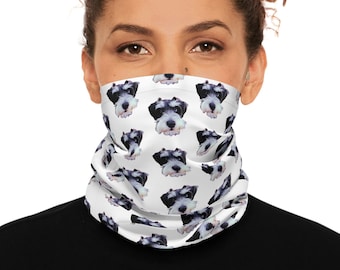 May include: A white neck gaiter featuring a repeating pattern of Schnauzer dog faces in black, white, and gray. The gaiter is worn around the neck and covers the lower face. The background is white.
