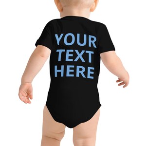 a baby wearing a black bodysuit with blue text