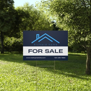 a real estate for sale sign in the grass