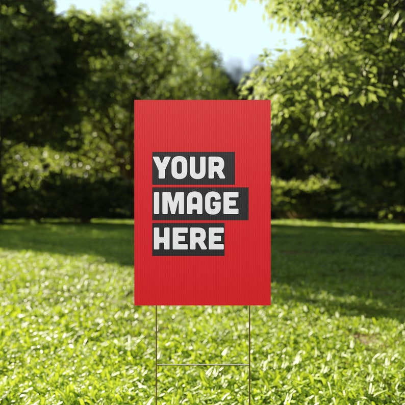 a red sign in the middle of a grassy field