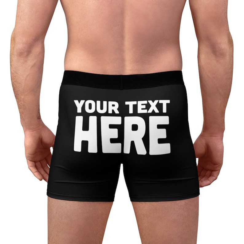 a man wearing a black boxer shorts with white text