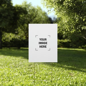 a white sign sitting on top of a lush green field